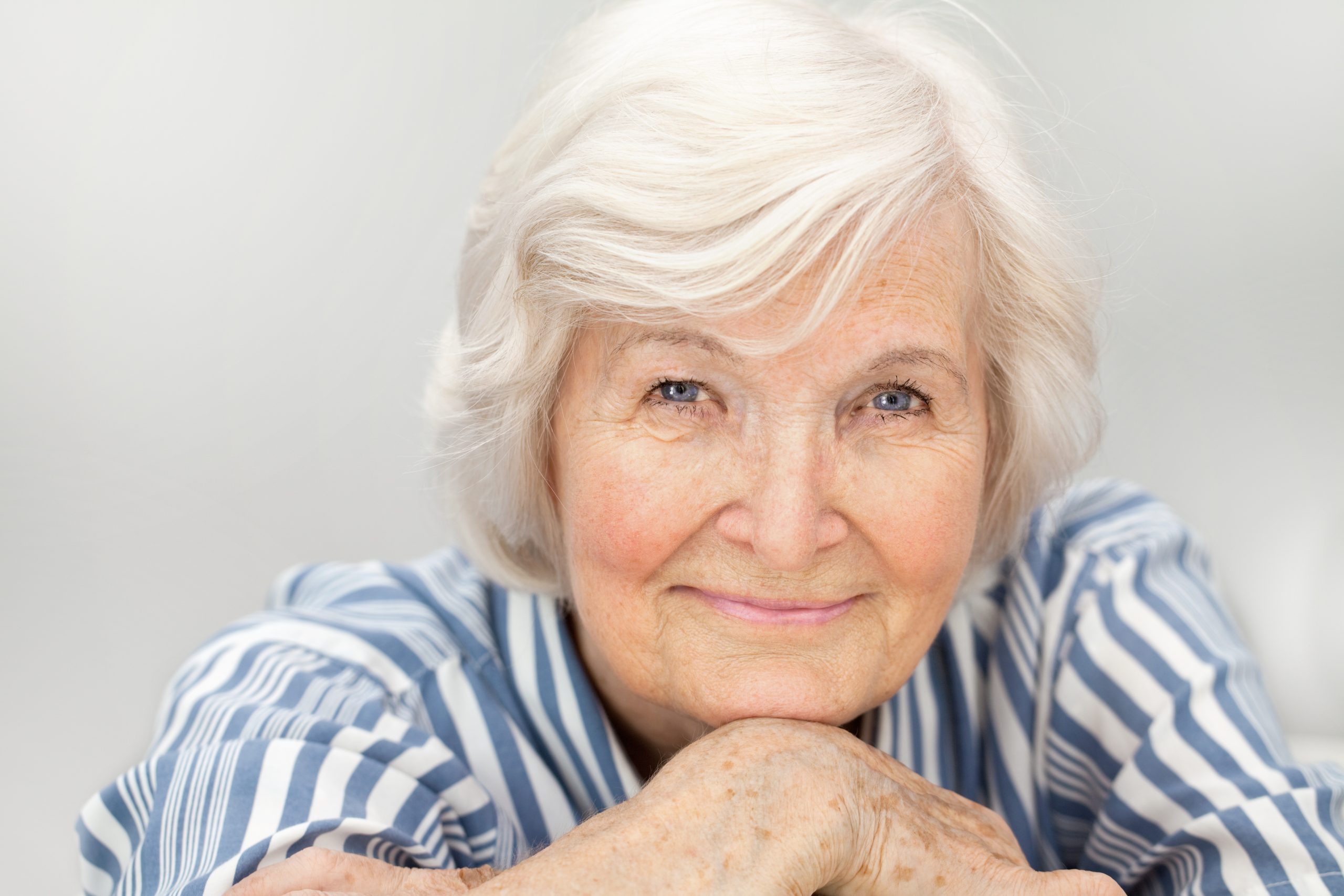 Senior,Woman,Portrait,,On,Grey,Background,With,White,Hair